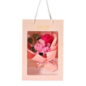 Pink soap flower bouquet in a gift bag with transparent window and gold lettering