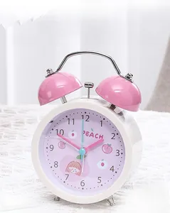 Close-up of pink twin bell alarm clock featuring a cute peach dial and metal handle
