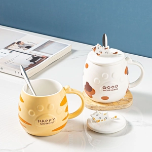 Creative cat ceramic mugs with 3D cat lids and metal spoons in a cozy home setting
