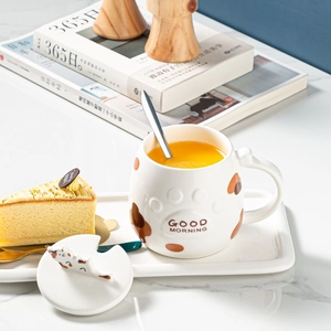 Detailed view of white ceramic cat mug with paw relief and 3D kitten lid plus spoon