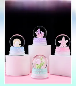 Detail view of four ocean-themed crystal balls with coral and starfish on wavy bases