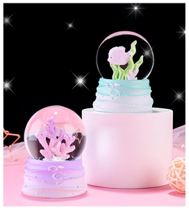 Detailed view of ocean theme snow globes with pink fish and coral on gradient pedestals