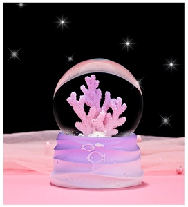 Close-up of ocean crystal ball with pink coral and embossed fish gradient base