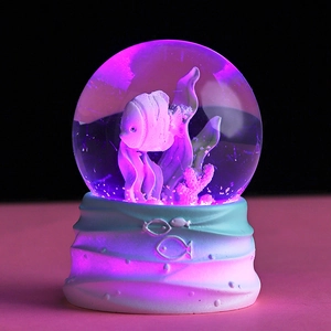 Luminous crystal ball with ocean fish theme and purple LED light on resin base