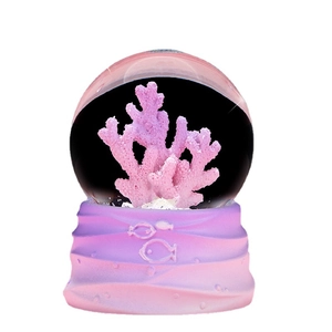 Ocean theme crystal ball with pink coral inside and gradient wave base desktop ornament