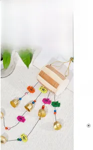 Détail d'un carillon de poisson en bois avec poissons colorés et cloches en laiton