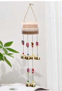 Détail d'un carillon papillon en bois fait main avec six cloches dorées pour la décoration