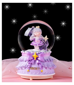 Détail de boîte à musique boule de cristal fille avec base en dentelle et nœud violet