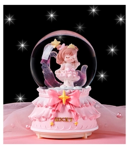 Détail d'une boîte à musique boule de cristal rose avec lettrage lucky et perles