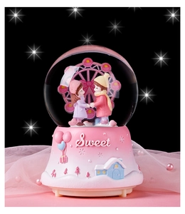 Detail of a romantic crystal ball featuring a couple and ferris wheel with a sweet base