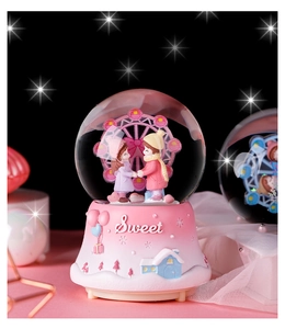 Detail of pink ferris wheel crystal ball music box with sweet couple and starry background