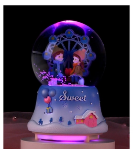 Macro detail of ferris wheel crystal ball featuring a sweet couple and LED base light