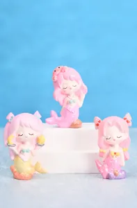 Detailweergave van drie schattige zeemeermin blind box figuren in roze en geel tinten