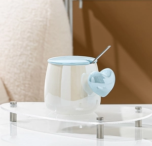 Detail of heart handle ceramic mug with pearlescent glaze, matching lid and spoon