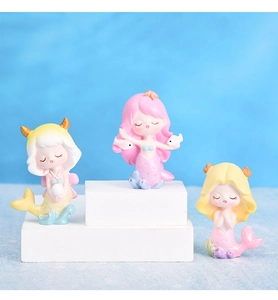 Trois figurines de sirène mignonnes aux couleurs pastel sur un podium blanc