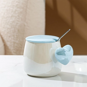 Detail of ceramic heart mug set with light blue handle and matching lid and spoon