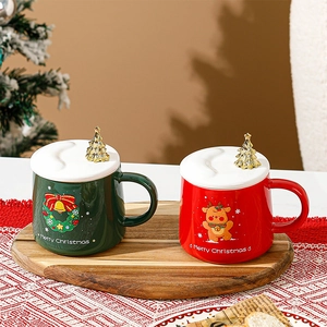 Détail de tasses de Noël en céramique avec motifs de renne et couronne sur plateau bois
