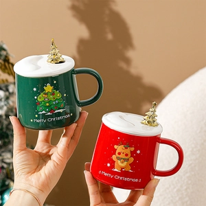 Détail de mugs de Noël rouge et vert avec couvercles à poignées en sapin doré