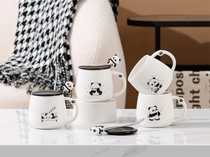Vista dettagliata di quattro tazze panda in ceramica con illustrazioni carine e cucchiai