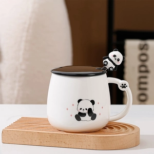 Dettaglio tazza in ceramica panda con cucchiaio 3D su vassoio di legno
