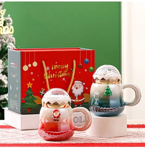 Nahaufnahme von Weihnachtsbechern mit Schneekugeldecke und festlicher Geschenkverpackung