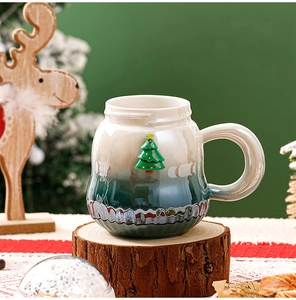 Nahaufnahme eines grünen Weihnachtsbechers aus Keramik auf rustikalem Holzsockel