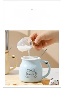 Action shot of pouring milk into a ceramic cat mug with a unique cat paw handle design