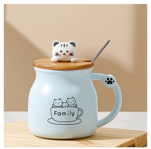Close-up of light blue ceramic cat mug with wooden lid, metal spoon and Family print