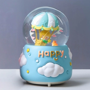 Detail of The Little Prince crystal ball showing a hot air balloon and golden stars