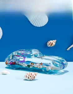 Detailed close-up of a blue ocean-themed car ornament with sea shells and sand
