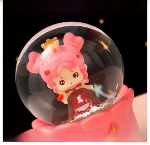 Detail shot of a pink princess figurine inside a crystal ball with floral base
