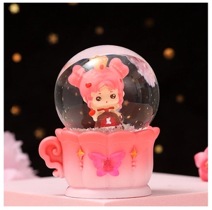 Close-up of glowing crystal ball ornament with cute cartoon girl and pink mug base