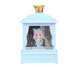 Blue castle musical snow globe with cute doll and golden crown on white background