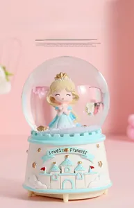 Detailed close-up of a dreamy castle princess music box snow globe with blue dress princess