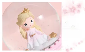 Close-up of a pink dream castle crystal ball music box with a princess and snowflakes