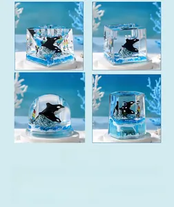Macro detail of three ocean orca resin paperweights in cube, sphere, and hexagon shapes