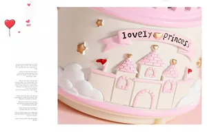 Detail of a pink resin music box base with 3D castle relief and Lovely Princess text