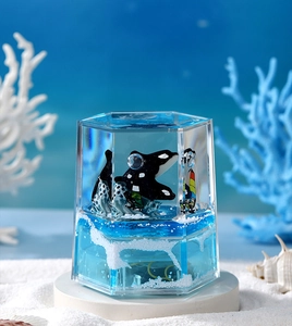 Detail of hexagonal ocean liquid timer with floating orcas and simulated white sea spray