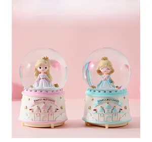 Detail of pink and blue crystal ball music boxes with lovely princess and castle