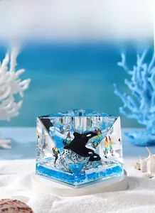 Detailed close-up of a blue ocean theme cube with orca and sailboat model decor