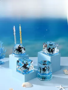 Detailed close-up of marine theme pen holder set with orca miniatures and sea wave decor