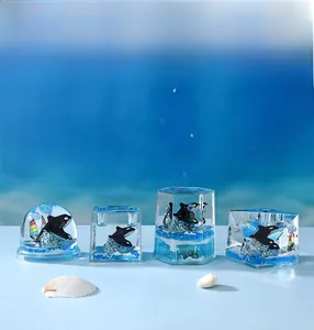 Macro view of ocean-themed resin paperweights with orca models and blue stone bases
