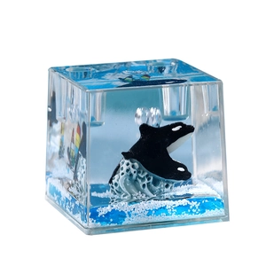 Ocean themed cube paperweight with floating orca model and blue liquid waves
