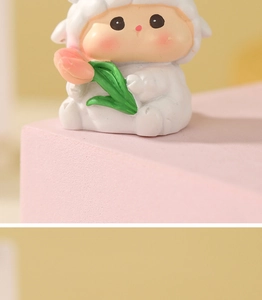Nahaufnahme einer süßen Schaf-Figur, die eine rosa Tulpe auf einem Display hält