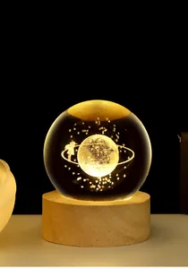 Macro detail of 3D galaxy laser carving inside a crystal ball on wooden base