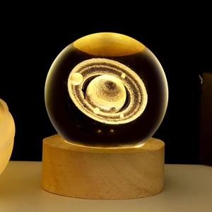 3D laser engraved Saturn crystal ball night light with textured wooden base and warm glow