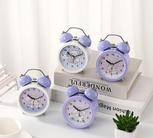 Detail view of retro twin bell alarm clock with cute cartoon pet illustrations and metal hands
