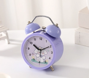 Detailed view of purple twin bell alarm clock featuring a cute cartoon dog on dial