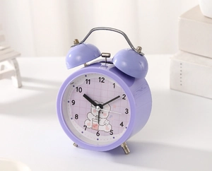 Detail view of a purple retro twin bell alarm clock with a cute cartoon bear illustration