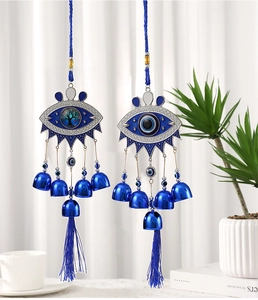 Detail of Turkish evil eye wall hanging with metal bells and blue tassels for home decor